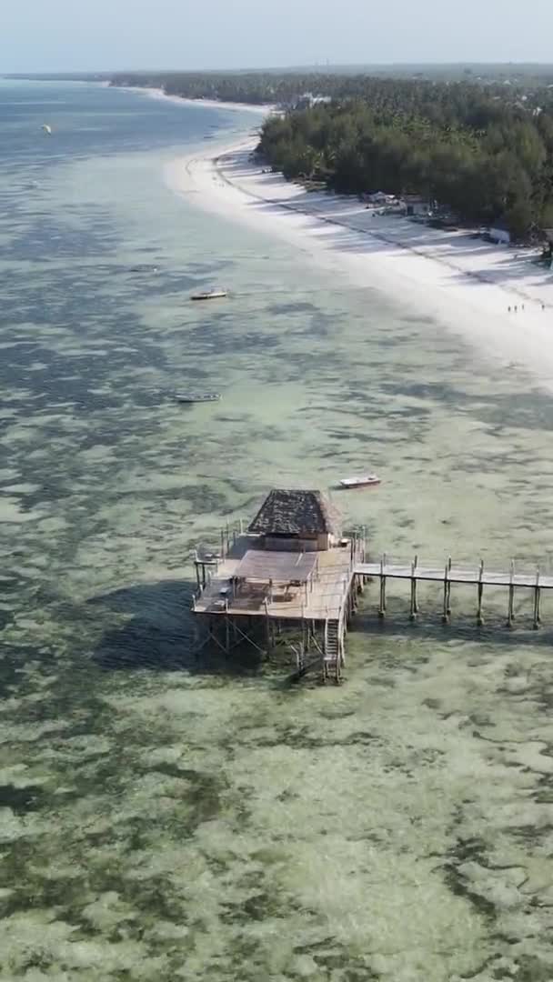 Casa de vídeo vertical sobre palafitas no oceano na costa de Zanzibar, na Tanzânia, vista aérea — Vídeo de Stock