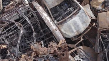 Bu video Irpin, Bucha bölgesinde, gri, düz, renksiz, yanmış arabaları gösteriyor.