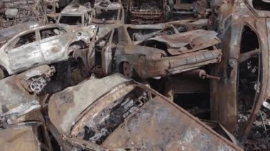 Bu video Irpin, Bucha bölgesinde, gri, düz, renksiz, yanmış arabaları gösteriyor.