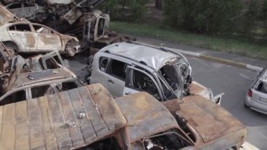 Bu video Irpin, Bucha bölgesinde, gri, düz, renksiz, yanmış arabaları gösteriyor.