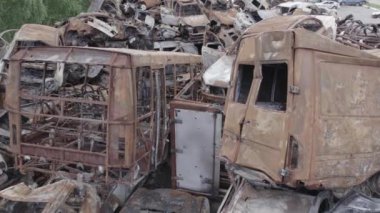 Bu video Irpin, Bucha bölgesinde, gri, düz, renksiz, yanmış arabaları gösteriyor.