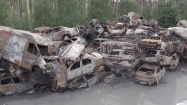 Bu video Irpin, Bucha bölgesinde, gri, düz, renksiz, yanmış arabaları gösteriyor.