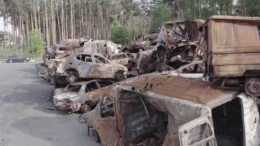 Bu video Irpin, Bucha bölgesinde, gri, düz, renksiz, yanmış arabaları gösteriyor.