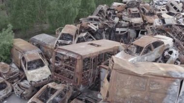 Bu video Irpin, Bucha bölgesinde, gri, düz, renksiz, yanmış arabaları gösteriyor.