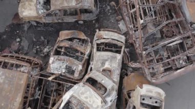 Bu video Irpin, Bucha bölgesinde, gri, düz, renksiz, yanmış arabaları gösteriyor.