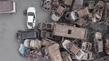 Bu video Irpin, Bucha bölgesinde, gri, düz, renksiz, yanmış arabaları gösteriyor.