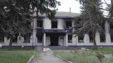 Bu stok videosu Ukrayna 'daki savaşın sonuçlarını gösteriyor. Borodyanka, Kyiv bölgesindeki polis karakolunun yıkılmış ve yanmış binası, gri, renksiz, düz.
