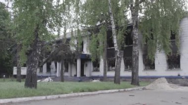 Bu stok videosu Ukrayna 'daki savaşın sonuçlarını gösteriyor. Borodyanka, Kyiv bölgesindeki polis karakolunun yıkılmış ve yanmış binası, gri, renksiz, düz.