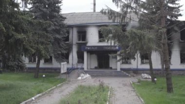 Bu stok videosu Ukrayna 'daki savaşın sonuçlarını gösteriyor. Borodyanka, Kyiv bölgesindeki polis karakolunun yıkılmış ve yanmış binası, gri, renksiz, düz.