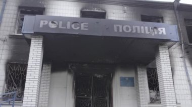 Bu stok videosu Ukrayna 'daki savaşın sonuçlarını gösteriyor. Borodyanka, Kyiv bölgesindeki polis karakolunun yıkılmış ve yanmış binası, gri, renksiz, düz.