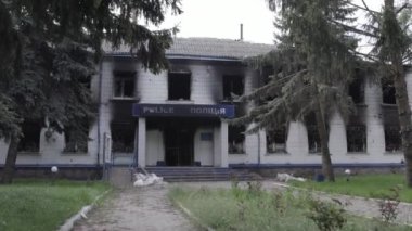 Bu stok videosu Ukrayna 'daki savaşın sonuçlarını gösteriyor. Borodyanka, Kyiv bölgesindeki polis karakolunun yıkılmış ve yanmış binası, gri, renksiz, düz.