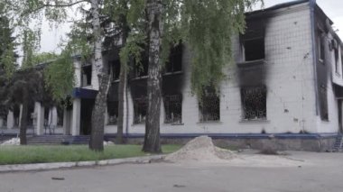 Bu stok videosu Ukrayna 'daki savaşın sonuçlarını gösteriyor. Borodyanka, Kyiv bölgesindeki polis karakolunun yıkılmış ve yanmış binası, gri, renksiz, düz.
