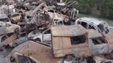 Bu video Irpin, Bucha bölgesinde, gri, düz, renksiz, yanmış arabaları gösteriyor.