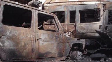 Bu video Irpin, Bucha bölgesinde, gri, düz, renksiz, yanmış arabaları gösteriyor.