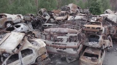 Bu video Irpin, Bucha bölgesinde, gri, düz, renksiz, yanmış arabaları gösteriyor.