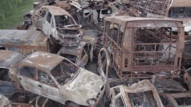 Bu video Irpin, Bucha bölgesinde, gri, düz, renksiz, yanmış arabaları gösteriyor.