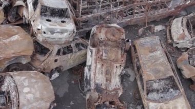 Bu video Irpin, Bucha bölgesinde, gri, düz, renksiz, yanmış arabaları gösteriyor.