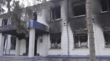 Bu stok videosu Ukrayna 'daki savaşın sonuçlarını gösteriyor. Borodyanka, Kyiv bölgesindeki polis karakolunun yıkılmış ve yanmış binası, gri, renksiz, düz.