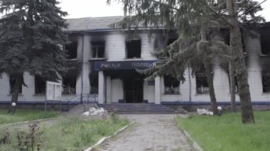 Bu stok videosu Ukrayna 'daki savaşın sonuçlarını gösteriyor. Borodyanka, Kyiv bölgesindeki polis karakolunun yıkılmış ve yanmış binası, gri, renksiz, düz.