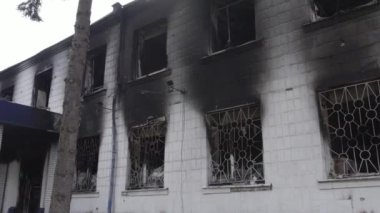 Bu stok videosu Ukrayna 'daki savaşın sonuçlarını gösteriyor. Borodyanka, Kyiv bölgesindeki polis karakolunun yıkılmış ve yanmış binası, gri, renksiz, düz.