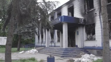 Bu stok videosu Ukrayna 'daki savaşın sonuçlarını gösteriyor. Borodyanka, Kyiv bölgesindeki polis karakolunun yıkılmış ve yanmış binası, gri, renksiz, düz.