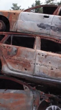 Bu stok dikey video Irpin, Bucha bölgesinde bir kurşun ve yanmış araba dökümü gösteriyor.