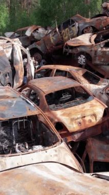 Bu stok dikey video Irpin, Bucha bölgesinde bir kurşun ve yanmış araba dökümü gösteriyor.