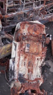 Bu stok dikey video Irpin, Bucha bölgesinde bir kurşun ve yanmış araba dökümü gösteriyor.