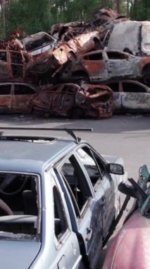 Bu stok dikey video Irpin, Bucha bölgesinde bir kurşun ve yanmış araba dökümü gösteriyor.