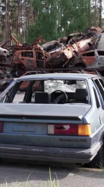 Bu stok dikey video Irpin, Bucha bölgesinde bir kurşun ve yanmış araba dökümü gösteriyor.