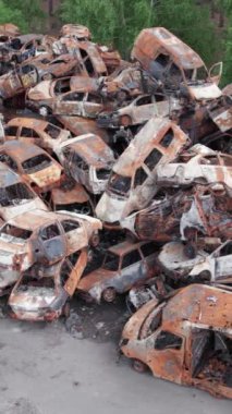 Bu stok dikey video Irpin, Bucha bölgesinde bir kurşun ve yanmış araba dökümü gösteriyor.