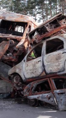 Bu stok dikey video Irpin, Bucha bölgesinde bir kurşun ve yanmış araba dökümü gösteriyor.