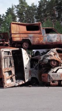 Bu stok dikey video Irpin, Bucha bölgesinde bir kurşun ve yanmış araba dökümü gösteriyor.