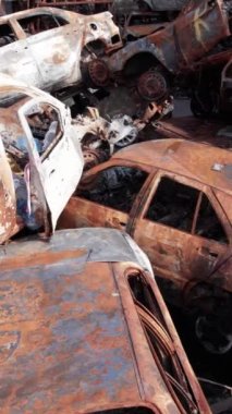 Bu stok dikey video Irpin, Bucha bölgesinde bir kurşun ve yanmış araba dökümü gösteriyor.