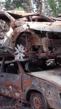 Bu stok dikey video Irpin, Bucha bölgesinde bir kurşun ve yanmış araba dökümü gösteriyor.