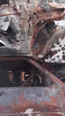 Bu stok dikey video Irpin, Bucha bölgesinde bir kurşun ve yanmış araba dökümü gösteriyor.