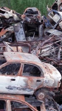 Bu stok dikey video Irpin, Bucha bölgesinde bir kurşun ve yanmış araba dökümü gösteriyor.