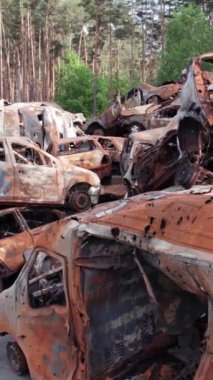 Bu stok dikey video Irpin, Bucha bölgesinde bir kurşun ve yanmış araba dökümü gösteriyor.