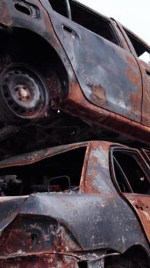 Bu stok dikey video Irpin, Bucha bölgesinde bir kurşun ve yanmış araba dökümü gösteriyor.