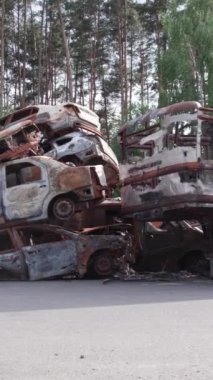 Bu stok dikey video Irpin, Bucha bölgesinde bir kurşun ve yanmış araba dökümü gösteriyor.