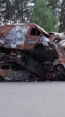 Bu stok dikey video Irpin, Bucha bölgesinde bir kurşun ve yanmış araba dökümü gösteriyor.