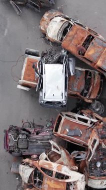 Bu stok dikey video Irpin, Bucha bölgesinde bir kurşun ve yanmış araba dökümü gösteriyor.