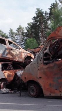 Bu stok dikey video Irpin, Bucha bölgesinde bir kurşun ve yanmış araba dökümü gösteriyor.