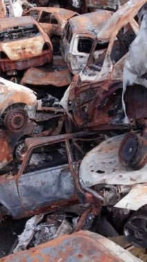 Bu stok dikey video Irpin, Bucha bölgesinde bir kurşun ve yanmış araba dökümü gösteriyor.