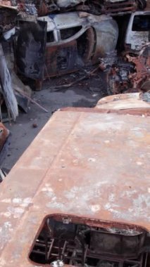 Bu stok dikey video Irpin, Bucha bölgesinde bir kurşun ve yanmış araba dökümü gösteriyor.