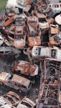 Bu stok dikey video Irpin, Bucha bölgesinde bir kurşun ve yanmış araba dökümü gösteriyor.