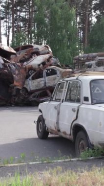 Bu stok dikey video Irpin, Bucha bölgesinde bir kurşun ve yanmış araba dökümü gösteriyor.