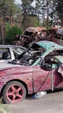 Bu stok dikey video Irpin, Bucha bölgesinde bir kurşun ve yanmış araba dökümü gösteriyor.