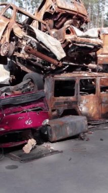 Bu stok dikey video Irpin, Bucha bölgesinde bir kurşun ve yanmış araba dökümü gösteriyor.