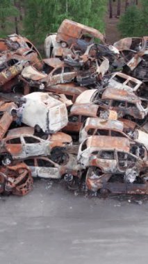 Bu stok dikey video Irpin, Bucha bölgesinde bir kurşun ve yanmış araba dökümü gösteriyor.